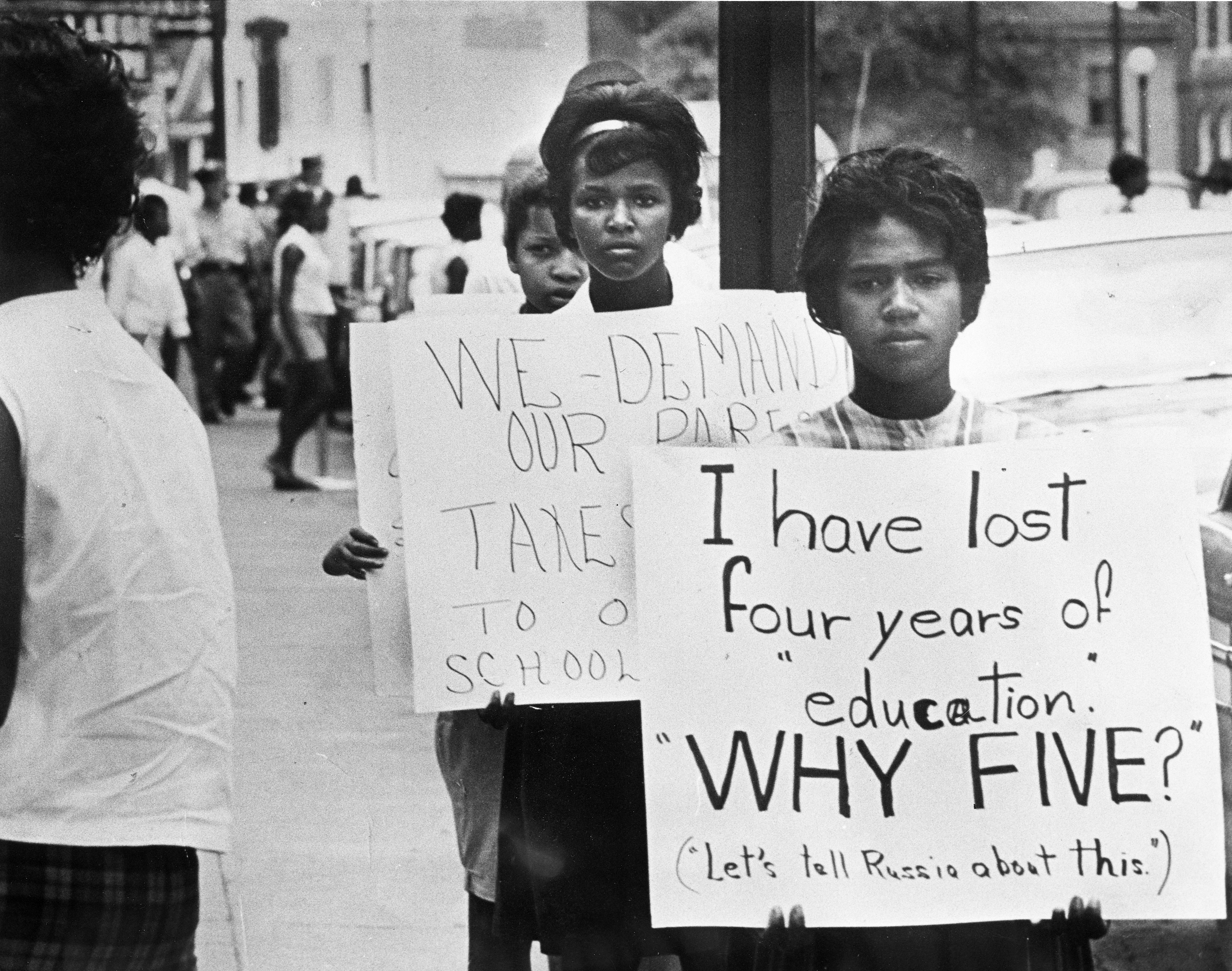 An image of several female African American teenagers holding picket signs